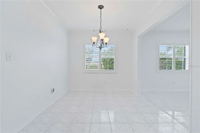 an empty room with windows and chandelier