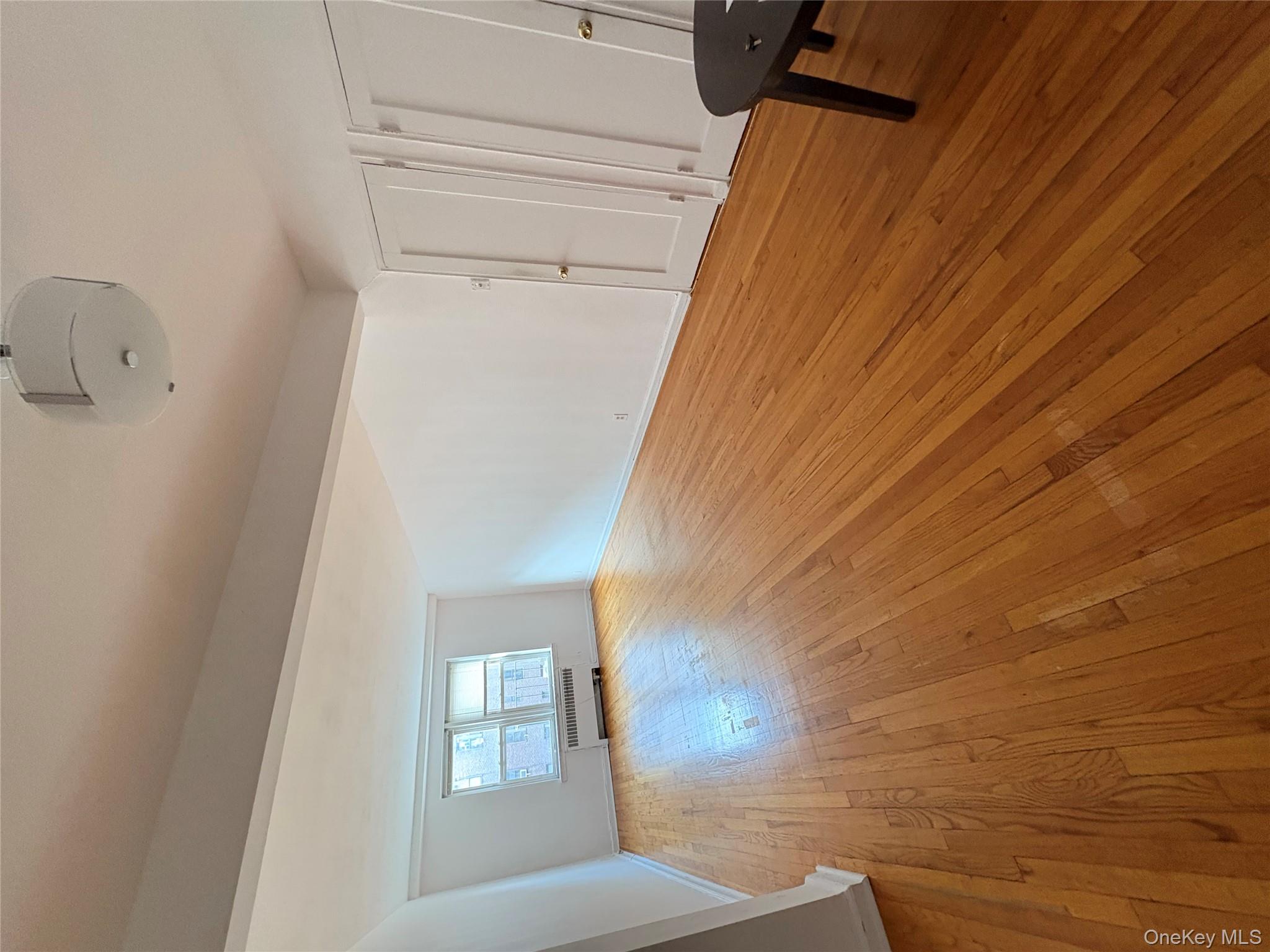 2090 Barnes Avenue, Unit 4D Bronx, NY 10462 - Photo 1 of 14 an empty room with wooden floor and windows
