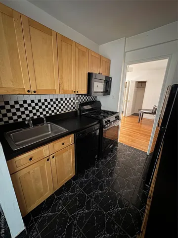 a kitchen with granite countertop stainless steel appliances a stove a sink and a microwave