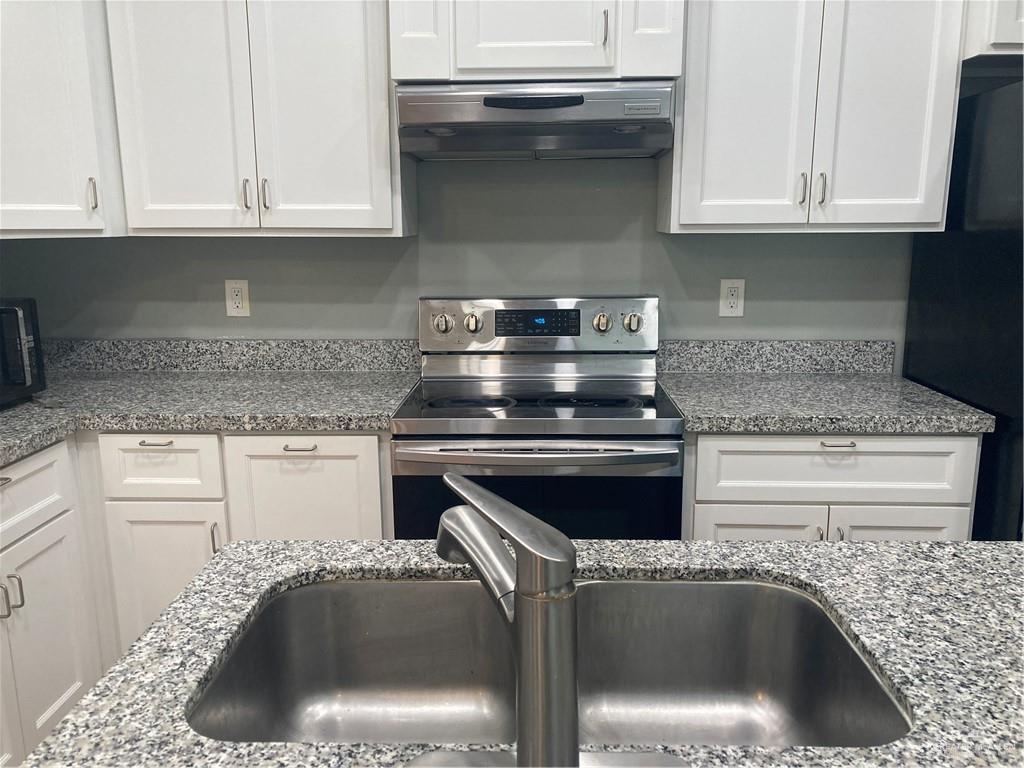 2103 South 6th Street McAllen, TX 78503 - Photo 8 of 33 Kitchen with stainless steel range with electric stovetop, white cabinetry, ventilation hood, and light stone counters
