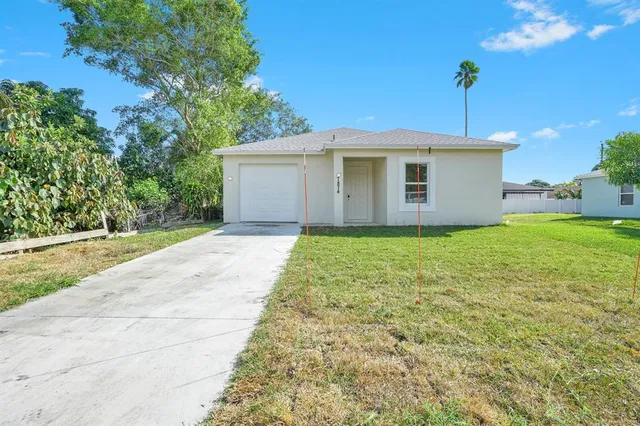 a front view of a house with yard and garage