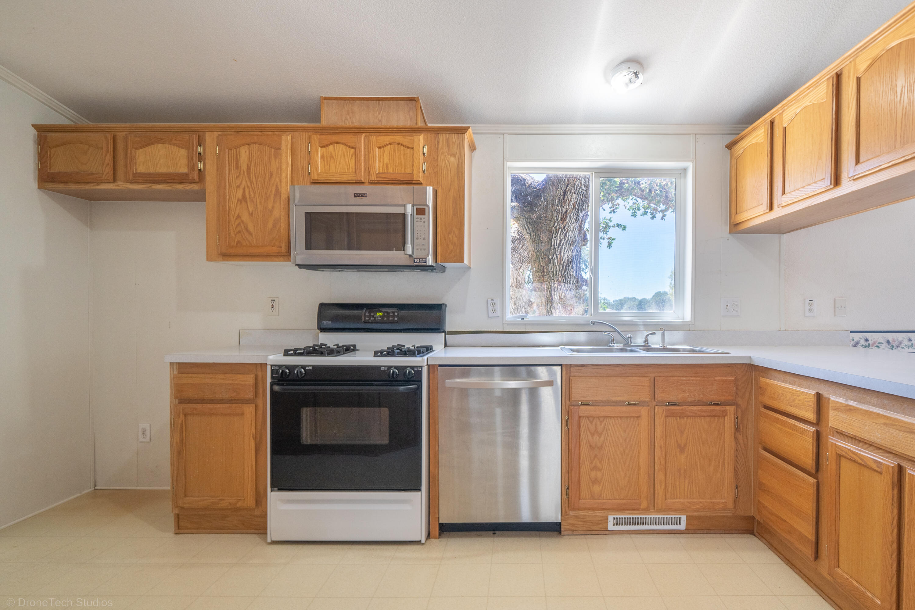 19035 Ridge Road Red Bluff, CA 96080 - Photo 19 of 74 a kitchen with stainless steel appliances granite countertop a stove a sink and a microwave