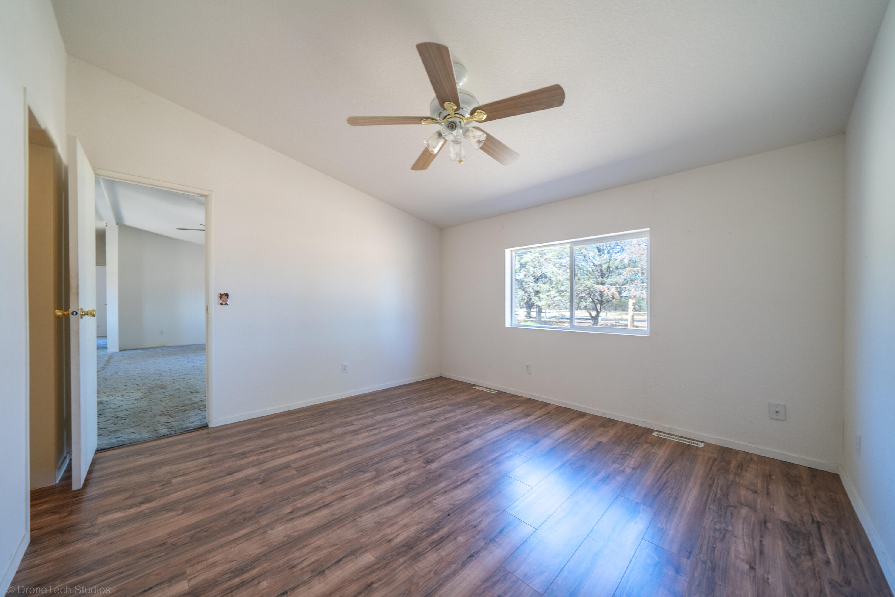 19035 Ridge Road Red Bluff, CA 96080 - Photo 27 of 74 an empty room with wooden floor fan and windows