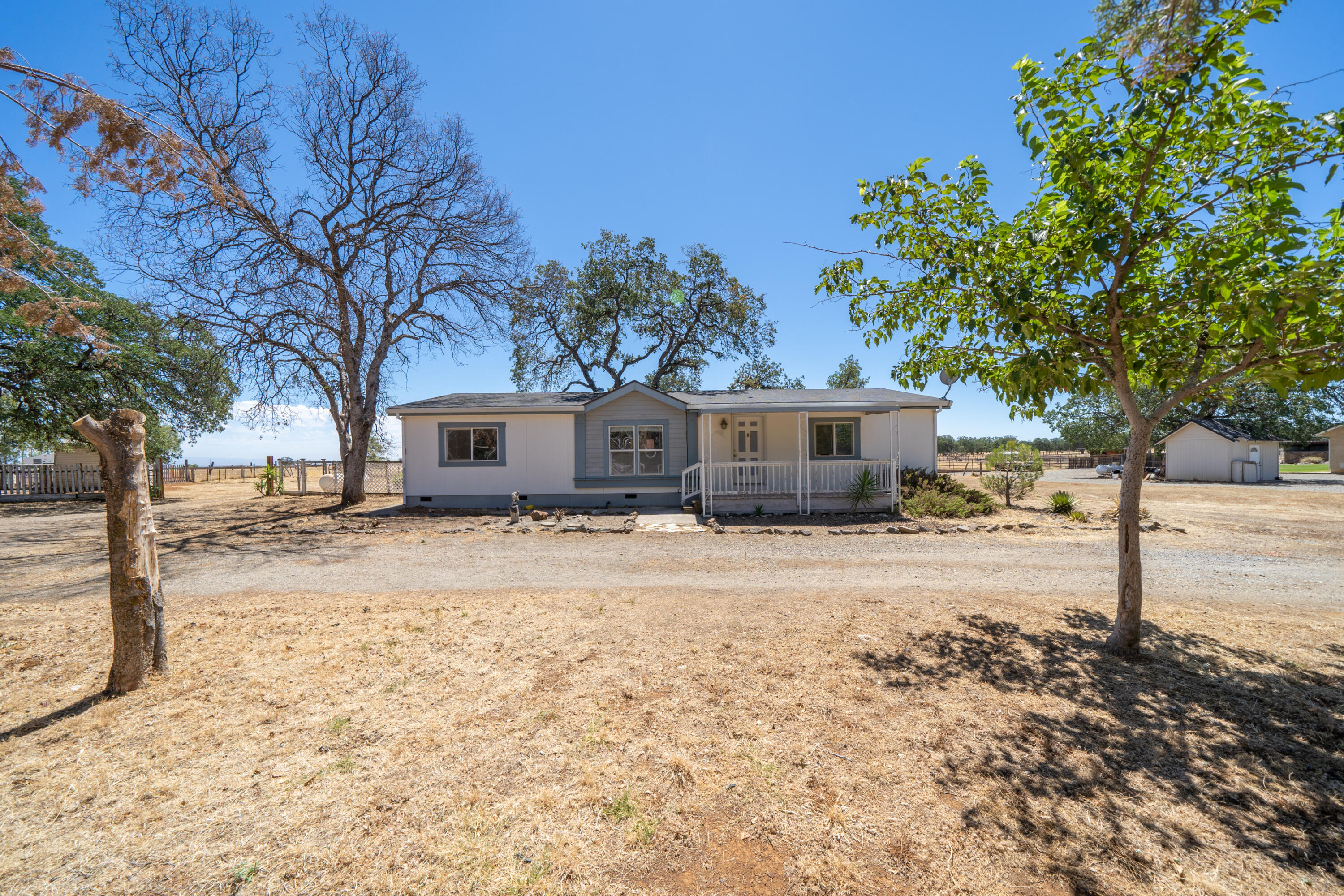 19035 Ridge Road Red Bluff, CA 96080 - Photo 3 of 74 a front view of a house with a yard and a garage