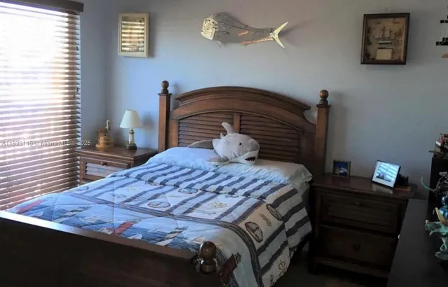 a bedroom with a bed and a lamp on the dresser