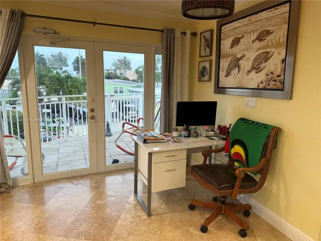 a view of a workspace with furniture and a window