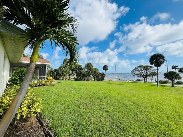 a view of a backyard with table and chairs and potted plants