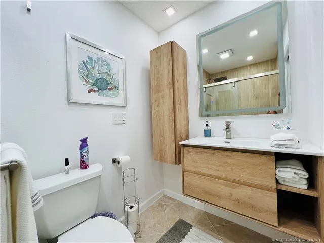 a en suite bathroom with a double vanity sink a mirror and a toilet