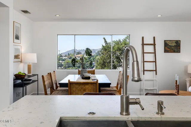 a kitchen with refrigerator a stove a sink and chairs