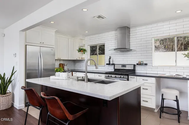 a kitchen with stainless steel appliances a sink and wooden cabinets