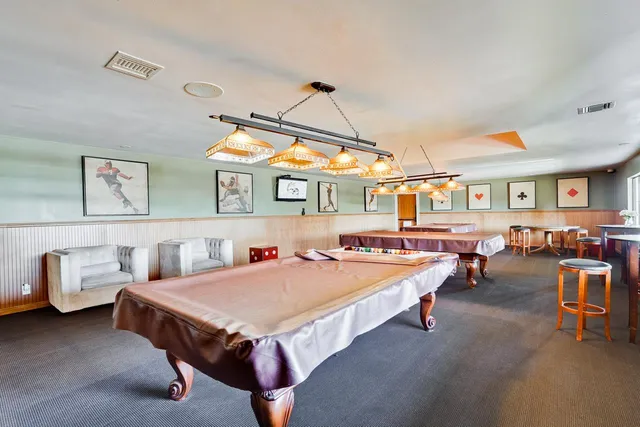 a view of a dining room with furniture a rug and a painting