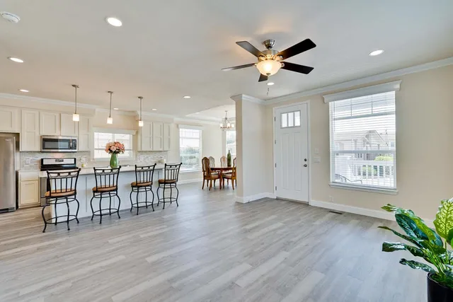 a view of a livingroom with furniture a ceiling fan and wooden floor