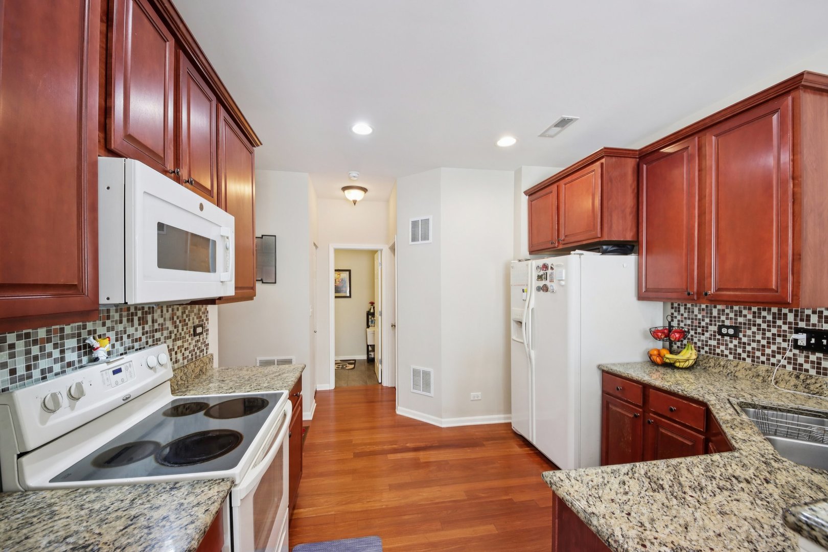424 Acushnet Street Elgin, IL 60124 - Photo 6 of 21 a kitchen with stainless steel appliances kitchen island granite countertop a refrigerator and a sink