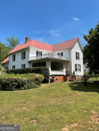 a front view of a house with swimming pool and furniture