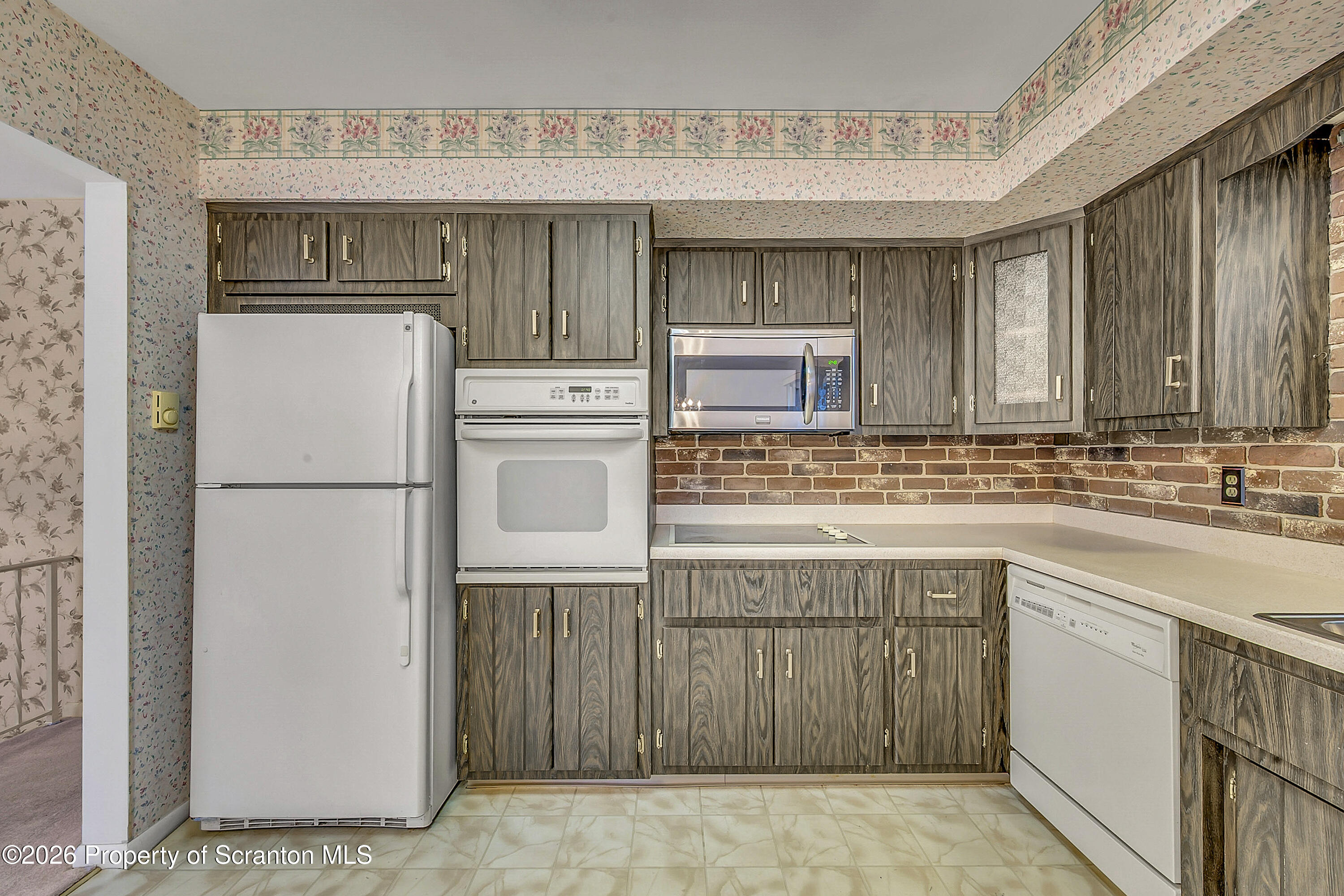 803 June Lane Moosic, PA 18507 - Photo 11 of 36 a kitchen with a sink refrigerator and cabinets