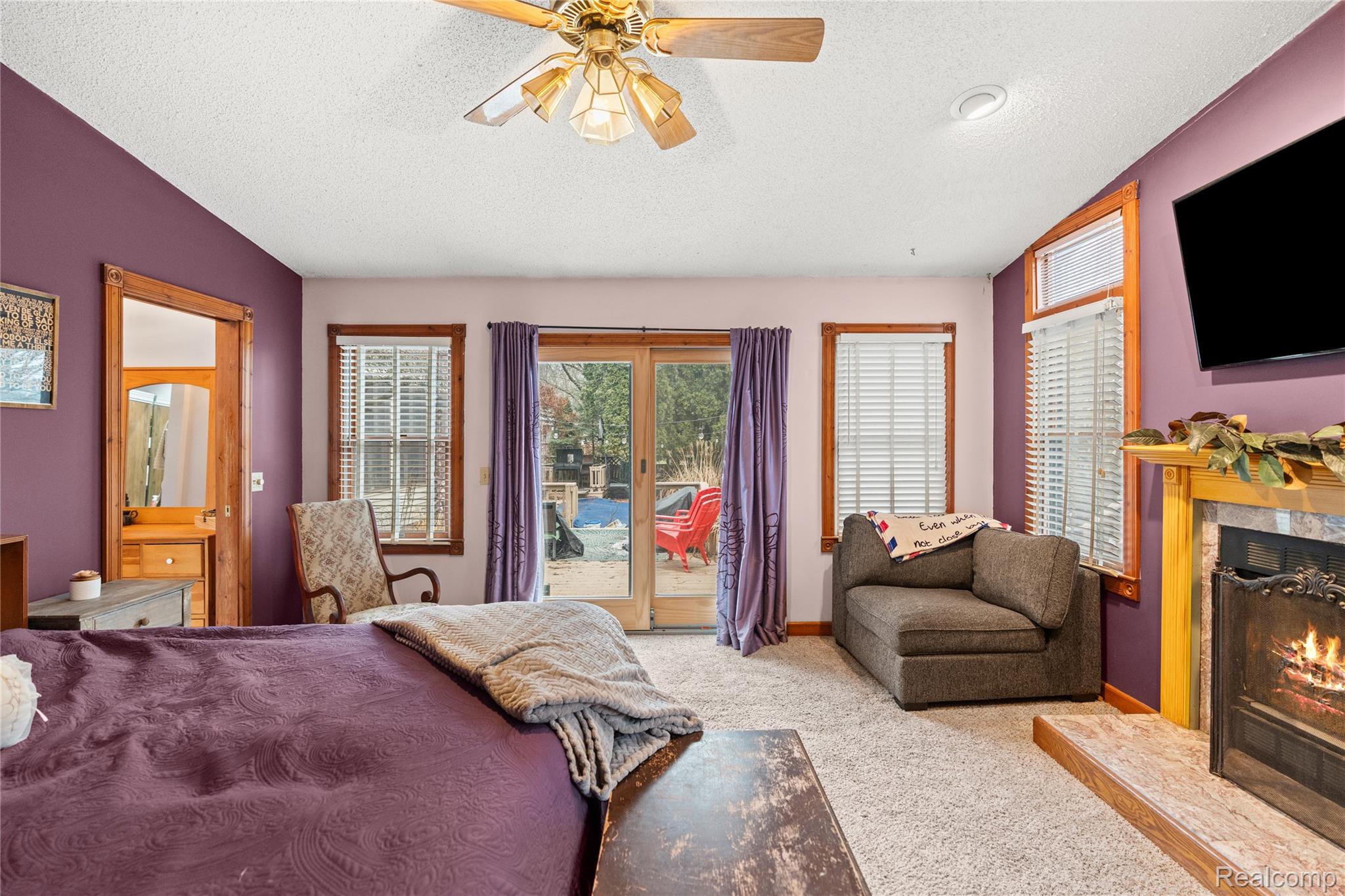 6076 East Carpenter Road Flint, MI 48506 - Photo 22 of 67 Carpeted bedroom with a premium fireplace, a ceiling fan, access to exterior, and french doors