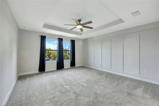 a view of an empty room with a window and a kitchen