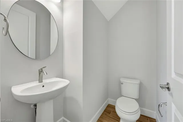 a bathroom with a toilet a sink and mirror