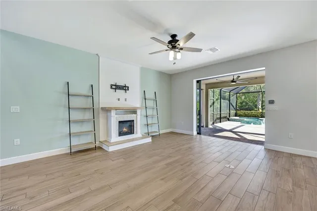 a view of a livingroom with wooden floor a fireplace and window