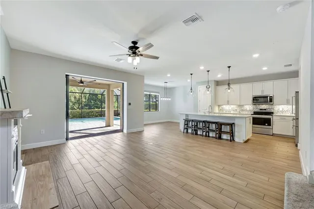 a kitchen with stainless steel appliances kitchen island wooden floors stove and cabinets