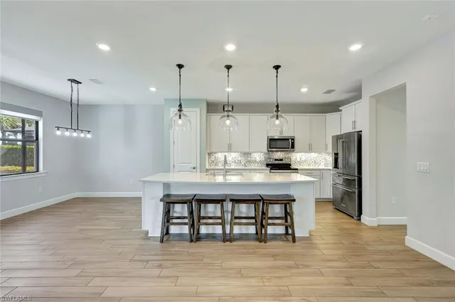 a large kitchen with cabinets wooden floor and stainless steel appliances