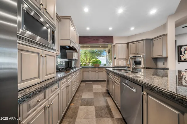 a large kitchen with stainless steel appliances granite countertop a lot of counter space