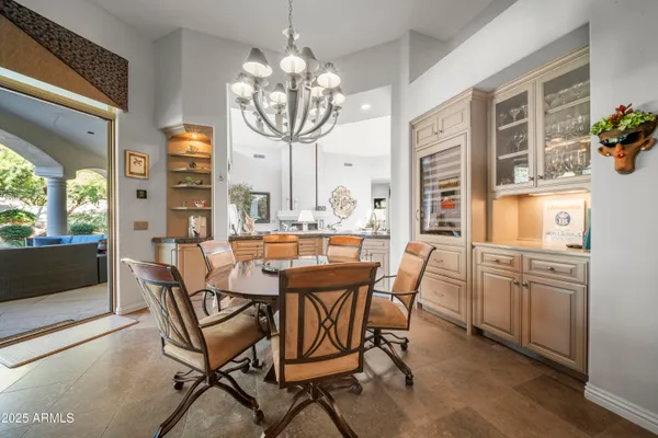 a view of a dining room with furniture a chandelier and wooden floor