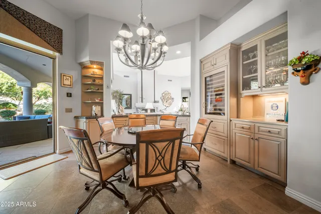 a view of a dining room with furniture a chandelier and wooden floor