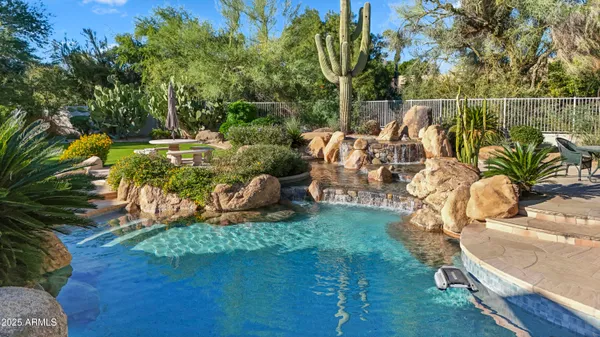 a view of a swimming pool with a patio and garden
