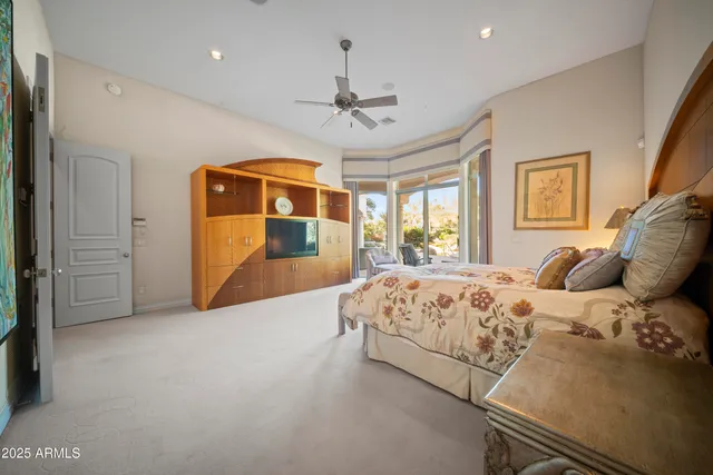 a spacious bedroom with a bed and a chandelier