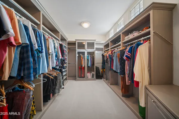 a view of walk in closet with clothes
