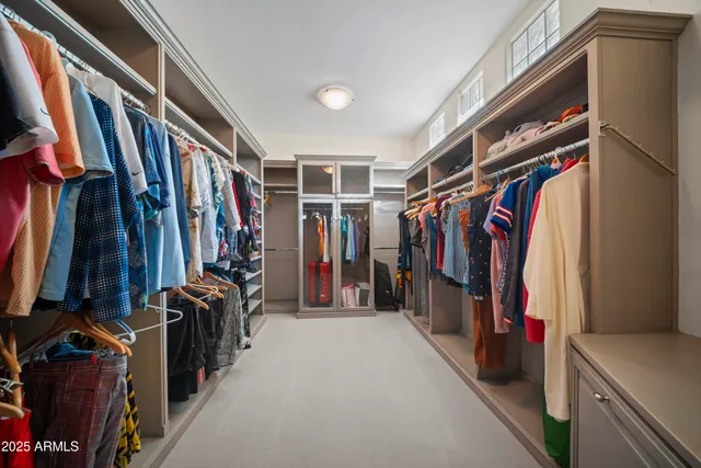 a view of walk in closet with clothes