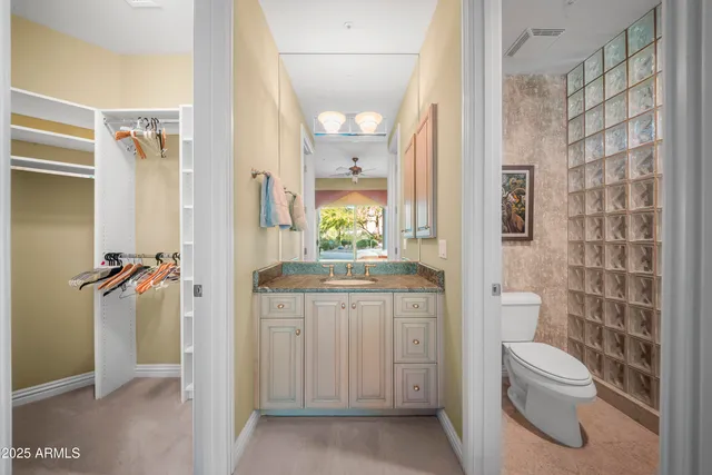 a bathroom with a granite countertop toilet a sink and a mirror