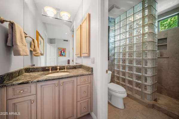 a bathroom with a granite countertop sink toilet and shower