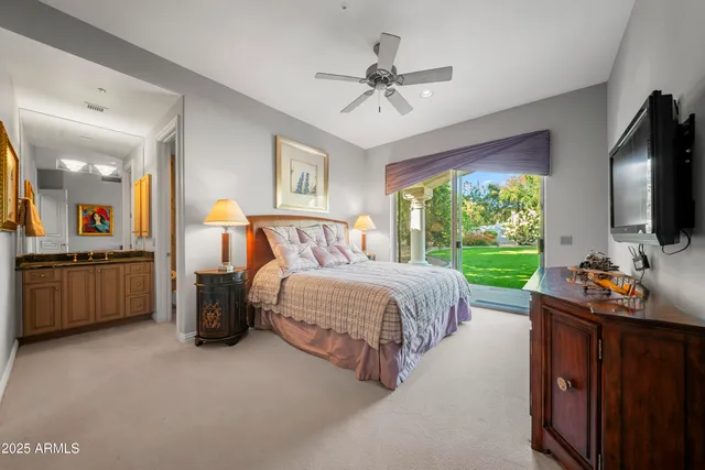 a bedroom with a bed and a flat tv screen on dresser