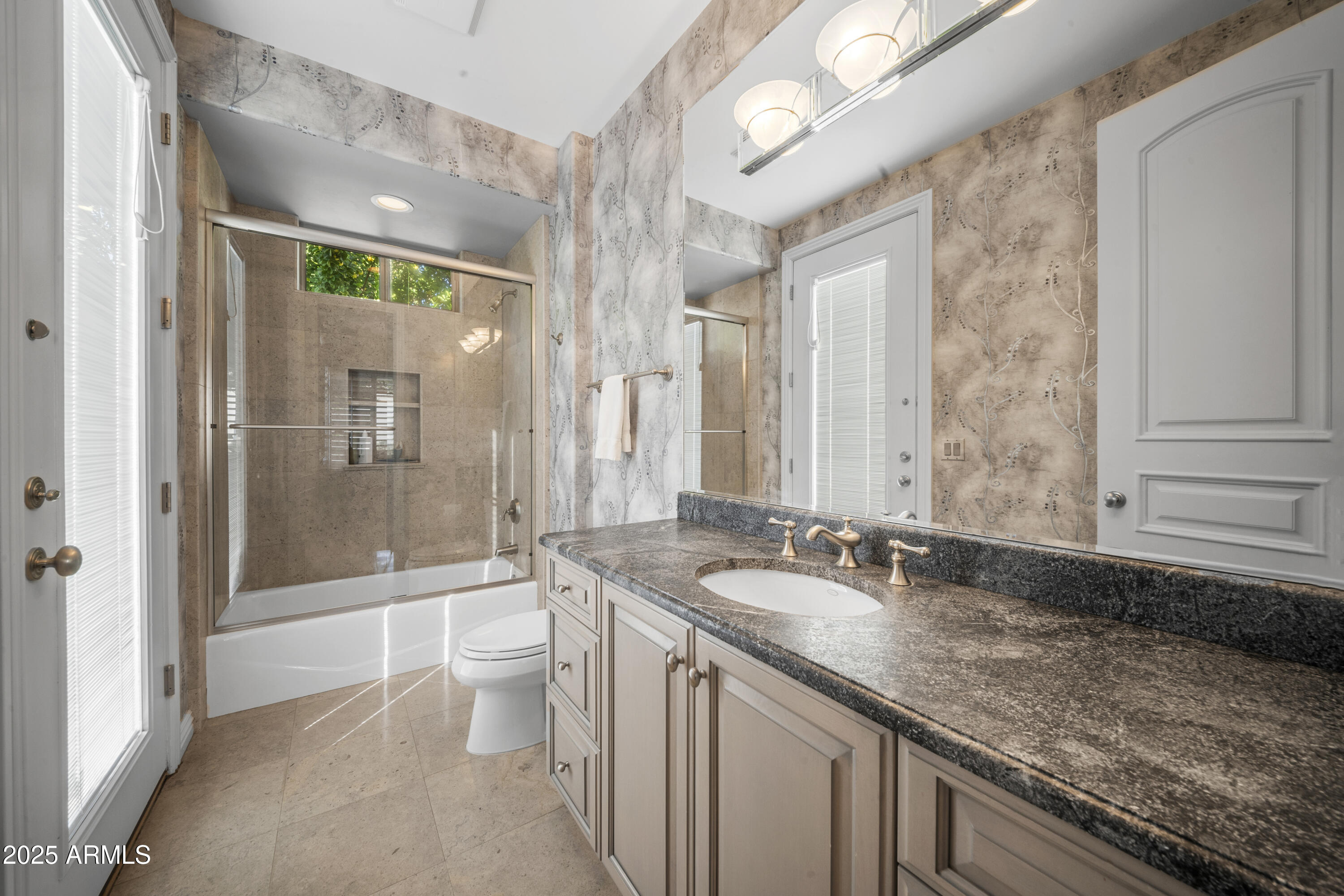 8350 East Via Del Sol Drive Scottsdale, AZ 85255 - Photo 32 of 42 a bathroom with a granite countertop sink a toilet a mirror and shower