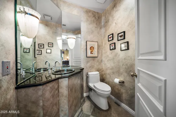 a bathroom with a granite countertop sink a toilet and mirror