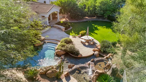 an aerial view of a house with swimming pool and red chairs