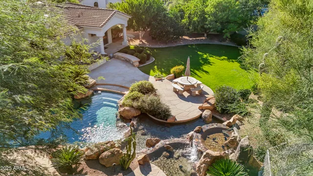 an aerial view of a house with swimming pool and red chairs
