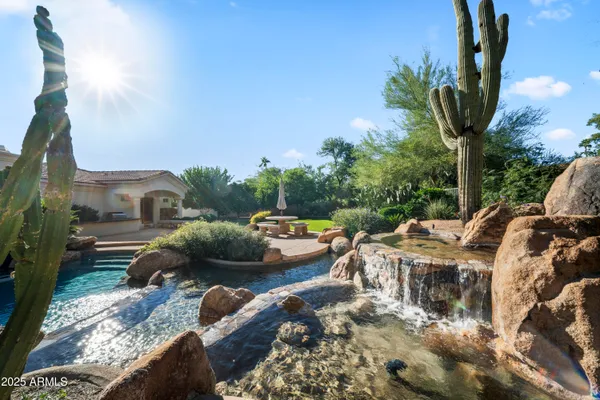 a front view of a house with garden and trees