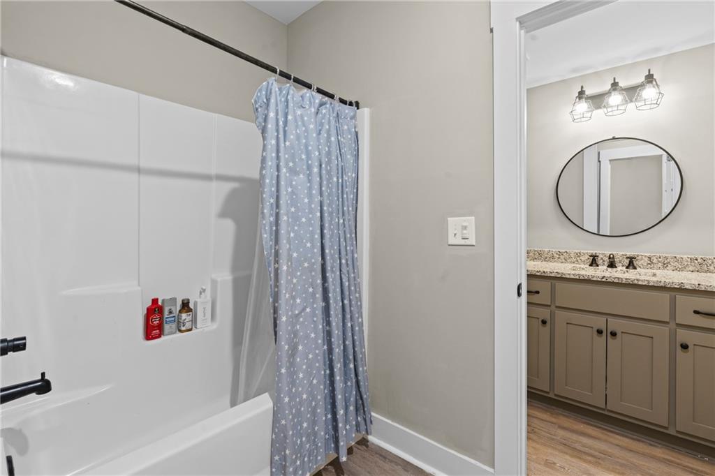 211 Cowart Road Dawsonville, GA 30534 - Photo 46 of 101 a bathroom with a granite countertop sink a mirror and a bathtub