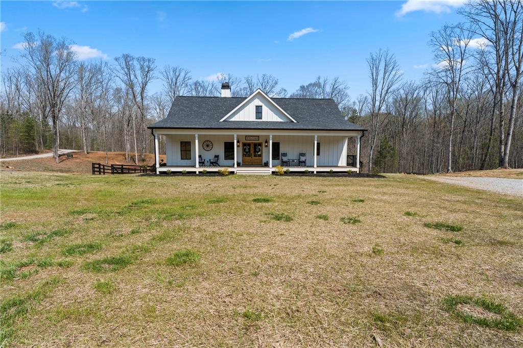 211 Cowart Road Dawsonville, GA 30534 - Photo 5 of 101 a front view of a house with a garden and trees