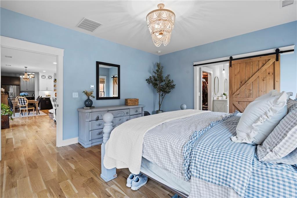 211 Cowart Road Dawsonville, GA 30534 - Photo 53 of 101 a bedroom with a large bed and a chandelier