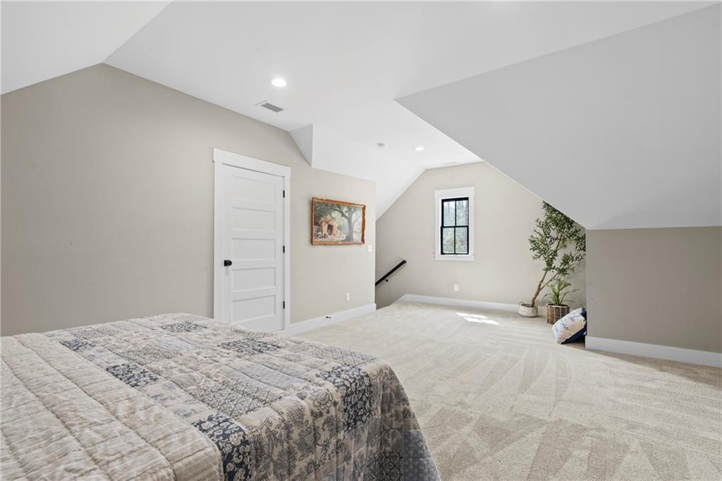 211 Cowart Road Dawsonville, GA 30534 - Photo 76 of 101 a bedroom with a large bed and a chandelier