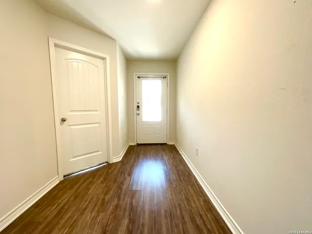 a view of a room with wooden floor and a window