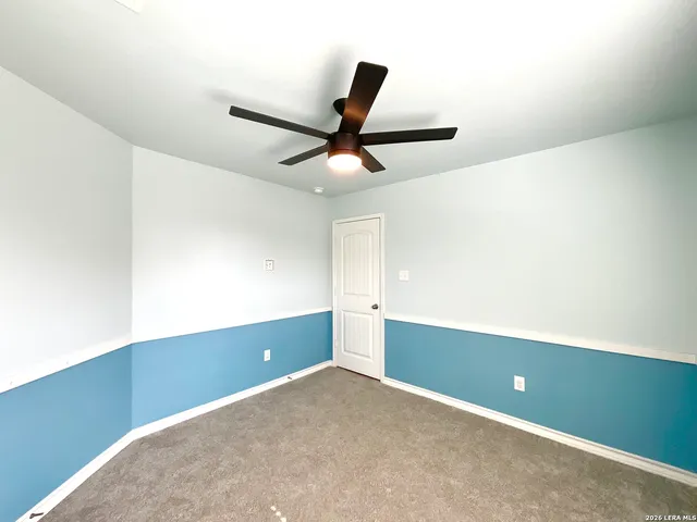 an empty room with a window and a fan