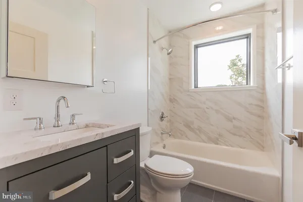 a bathroom with a sink a toilet and bathtub