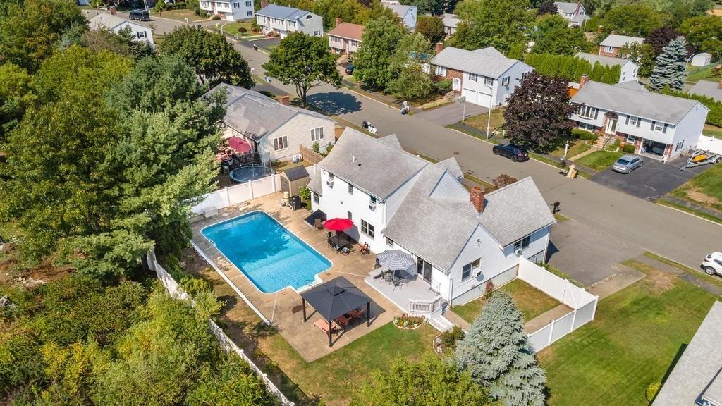 an aerial view of a house with swimming pool and outdoor seating