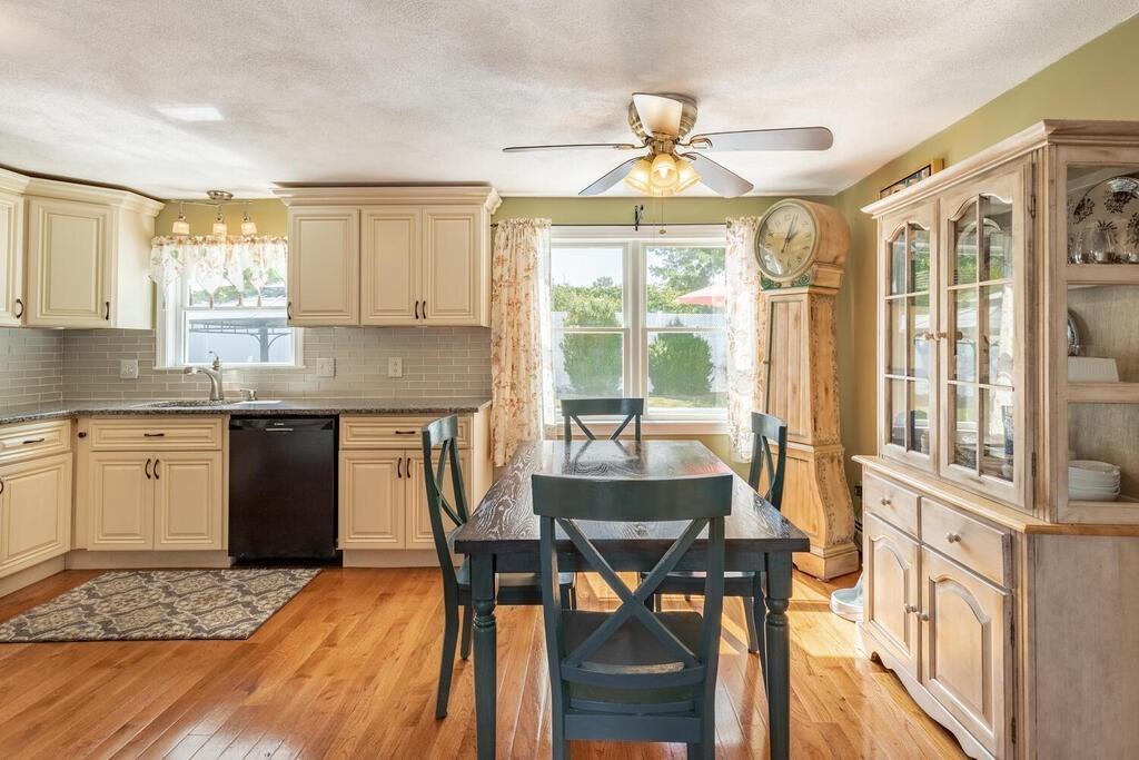 10 John Road Peabody, MA 01960 - Photo 14 of 35 a kitchen with granite countertop a stove a sink dishwasher a dining table and chairs with wooden floor