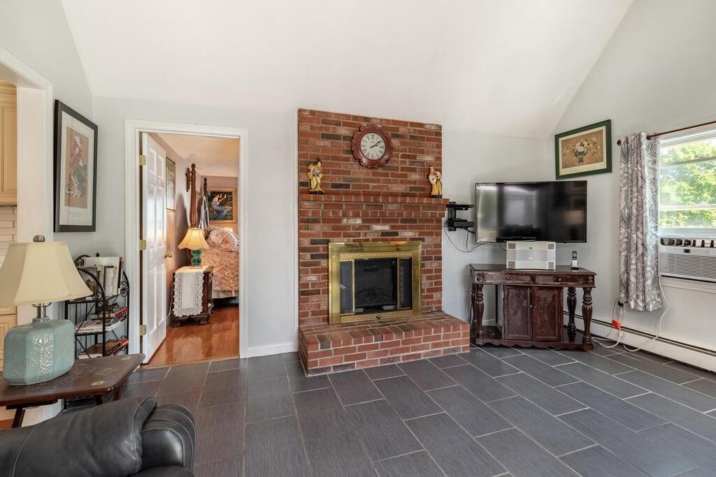 10 John Road Peabody, MA 01960 - Photo 18 of 35 a living room with furniture a flat screen tv and a fireplace